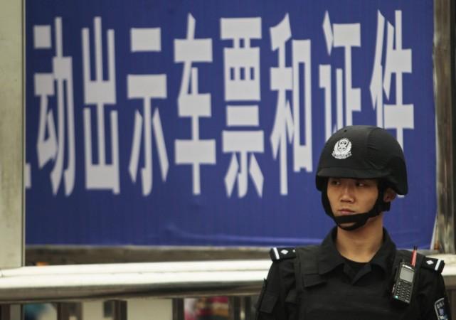 A policeman stands guard at a railway station after a knife attack in Guangzhou, Guangdong province May 6, 2014. REUTERS/Alex Lee