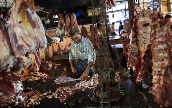A butcher cuts up portions of beef for sale in an abattoir at a wholesale market in Mumbai (Reuters)