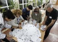 Members of local election commission empty ballot box as they start counting votes of referendum on status of Luhansk region in Luhansk.