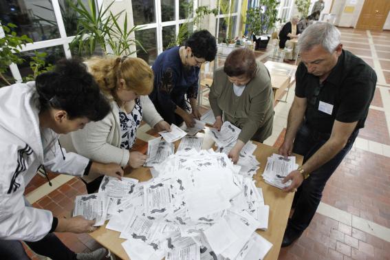 Members of local election commission empty ballot box as they start counting votes of referendum on status of Luhansk region in Luhansk.