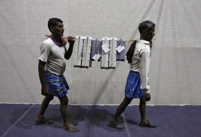 Labourers carry EVMs at an election material distribution centre on the eve of the final phase of general election in Kolkata