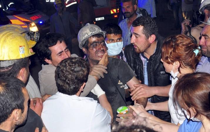 A rescued miner surrounded by relatives, medics and other miners cries after being rescued from a coal mine he was in trapped in Soma, a district in Turkey's western province of Manisa Turkey Coal Mine Fire