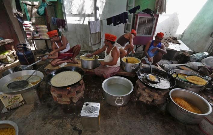 Sweets makers wearing caps of India's main opposition BJP prepare