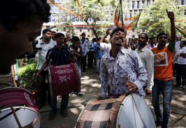 Supporters of the Bharatiya Janata Party (BJP) celebrate after learning of initial poll results outside their party office in Mumbai