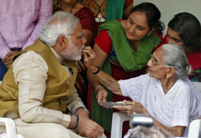 Hindu nationalist Modi, the prime ministerial candidate for India's BJP, talks with his mother Heeraben at her residence in Gandhinagar