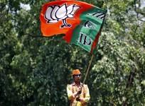 A supporter of BJP waves the party flag during celebrations after learning of initial poll results outside the party headquarters in New Delhi