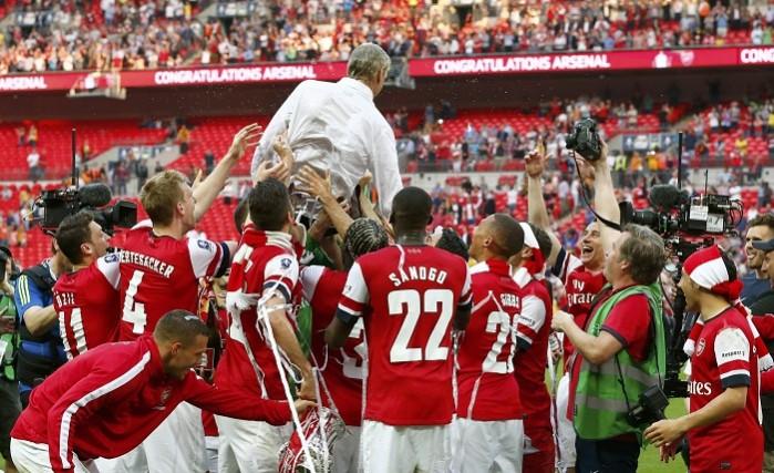 Arsenal manager Arsene Wenger is lifted by his players as they celebrate their victory against Hull City in the FA Cup final victory. Arsene Wenger