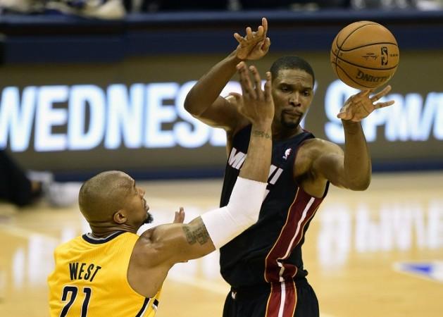 Miami Heat's Chris Bosh passes the ball around Indiana Pacers' David West. Chris Bosh