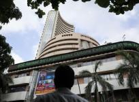 A man looks at a screen across the road displaying the election results on the facade of the BSE building in Mumbai