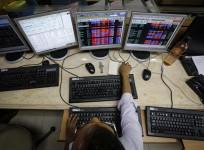 A broker monitors share prices while trading at a brokerage firm in Mumbai