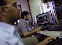 Brokers trade on their computer terminals at a stock brokerage firm in Mumbai