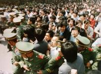 File photo of crowds of jubilant students surging through a police cordon before pouring into Tiananmen Square