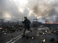 An anti-government protester runs trough the rubble after violence erupted in Ukraine protests