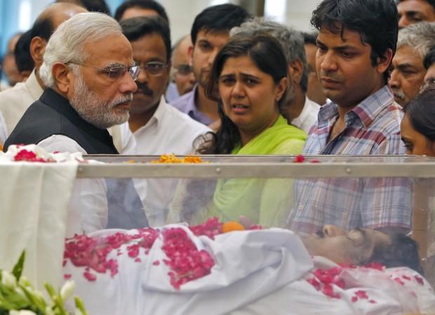 Modi looks at the casket of Munde, next to Munde's daughter, at BJP headquarters in New Delhi