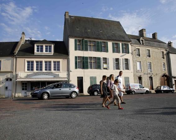 Tourists walk across the main square of Place Du Marche near the former D-Day landing zone of Omaha Beach