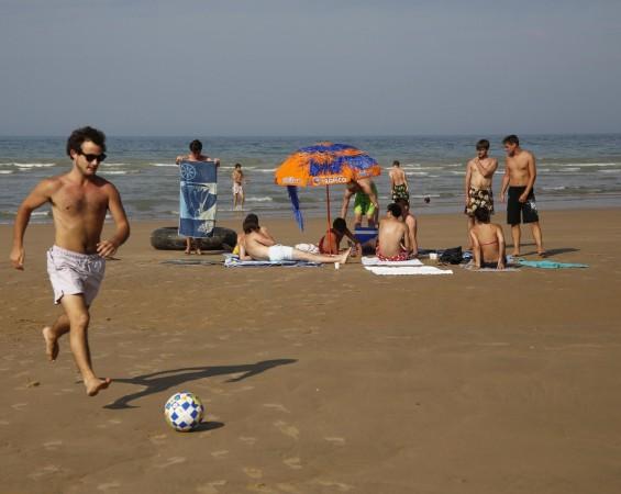 Youths enjoy the sunshine on the former D-Day landing zone of Omaha beach near Vierville sur Mer