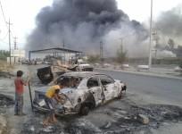 Civilian children stand next to a burnt vehicle during clashes between Iraqi security forces and al Qaeda-linked Islamic State in Iraq and the Levant (ISIL) in the northern Iraq city of Mosul