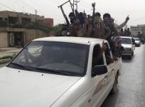 Fighters of the Islamic State of Iraq and the Levant (ISIL) celebrate, on vehicles taken from Iraqi security forces, at a street in city of Mosul