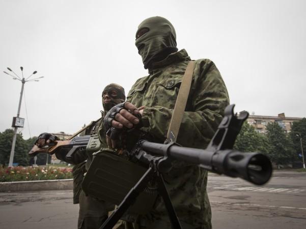 Armed pro-Russian separatists stand at a town center in Snizhnye in eastern Ukraine