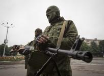 Armed pro-Russian separatists stand at a town center in Snizhnye in eastern Ukraine