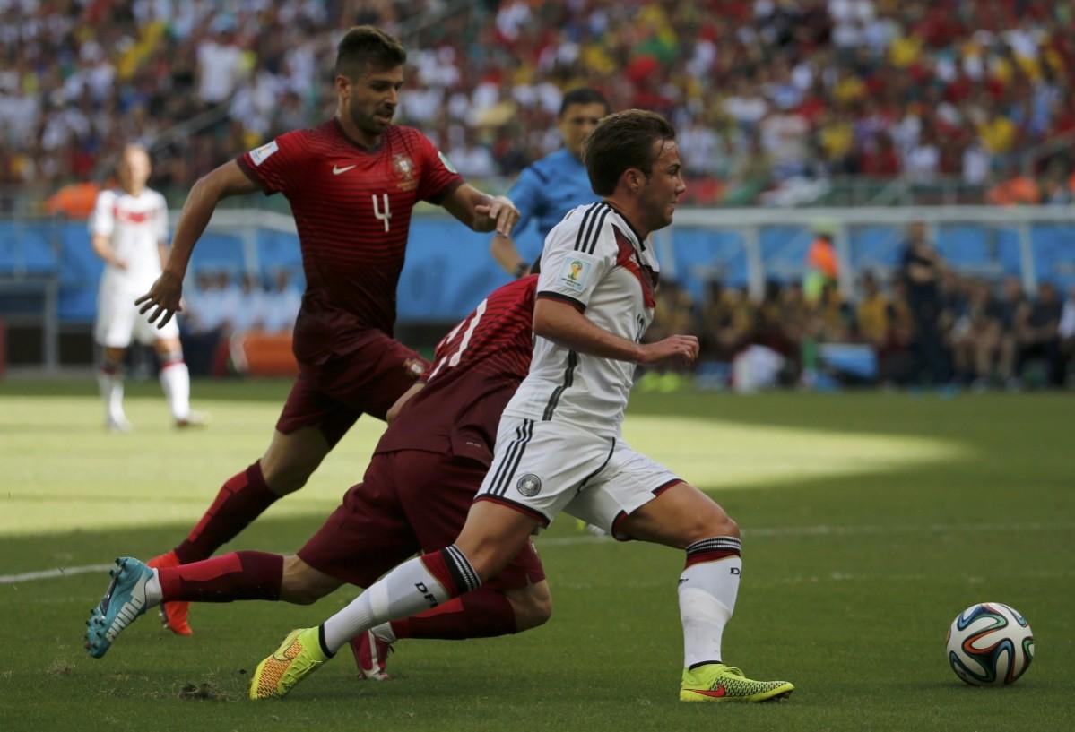 Portugal's Pereira commits a foul as he pulls Germany's Goetze by the shirt while fighting for the ball during their 2014 World Cup Group G soccer match at the Fonte Nova arena in Salvador Germany v Portugal