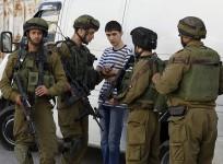 Israeli soldiers search a Palestinian youth during an operation to locate three Israeli teens in the West Bank city of Hebron June 16 2014.