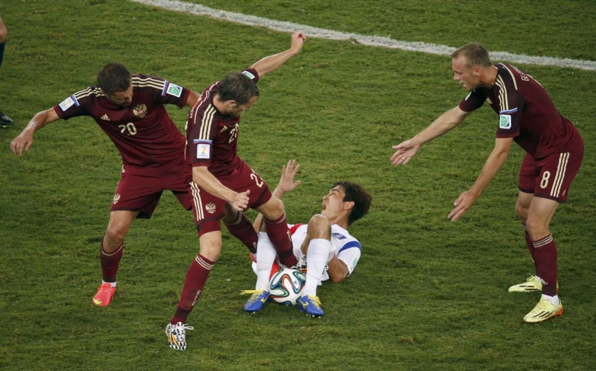 Russia's Victor Faizulin (L) and Dmitry Kombarov fight for the ball with South Korea's Park Chu-young during their 2014 World Cup Group H soccer match at the Pantanal arena Russia v South Korea