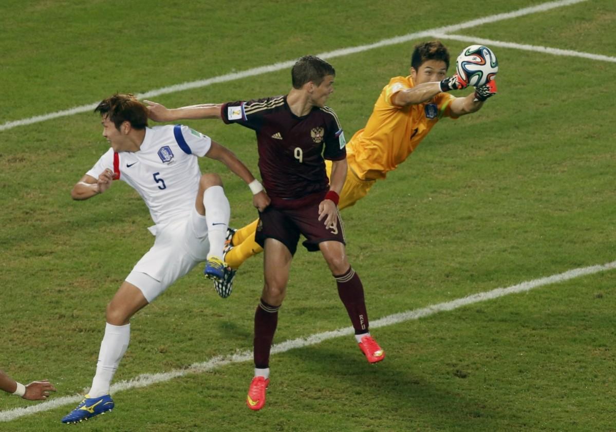South Korea's Jung punches the ball clear away from Russia's Kokorin during their 2014 World Cup Group H soccer match at the Pantanal arena in Cuiaba Russia v South Korea