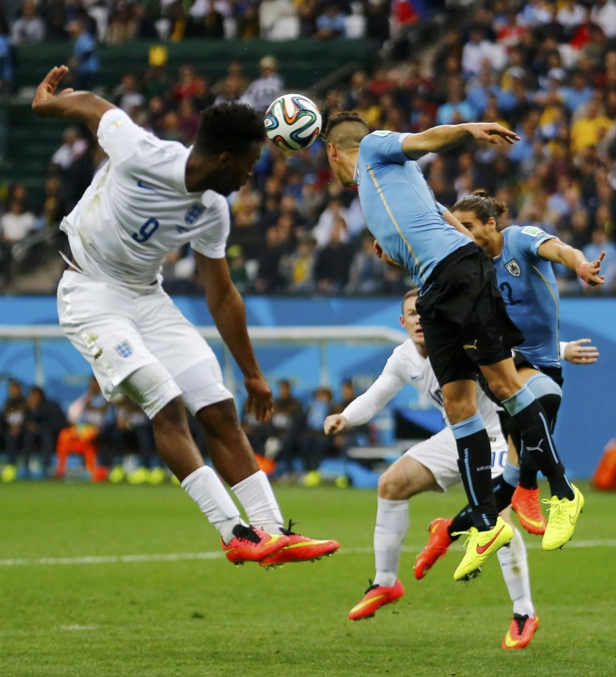 Uruguay's Maria Gimenez jumps for the ball with England's Sturridge during their 2014 World Cup Group D soccer match at the Corinthians arena in Sao Paulo Uruguay v England