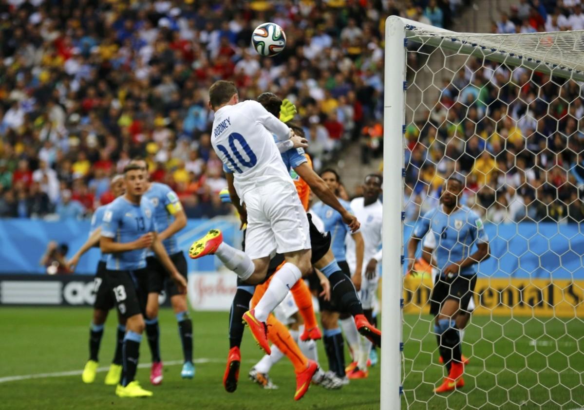 England's Wayne Rooney heads the ball into the crossbar during the 2014 World Cup Group D soccer match between Uruguay and England at the Corinthians arena Uruguay v England