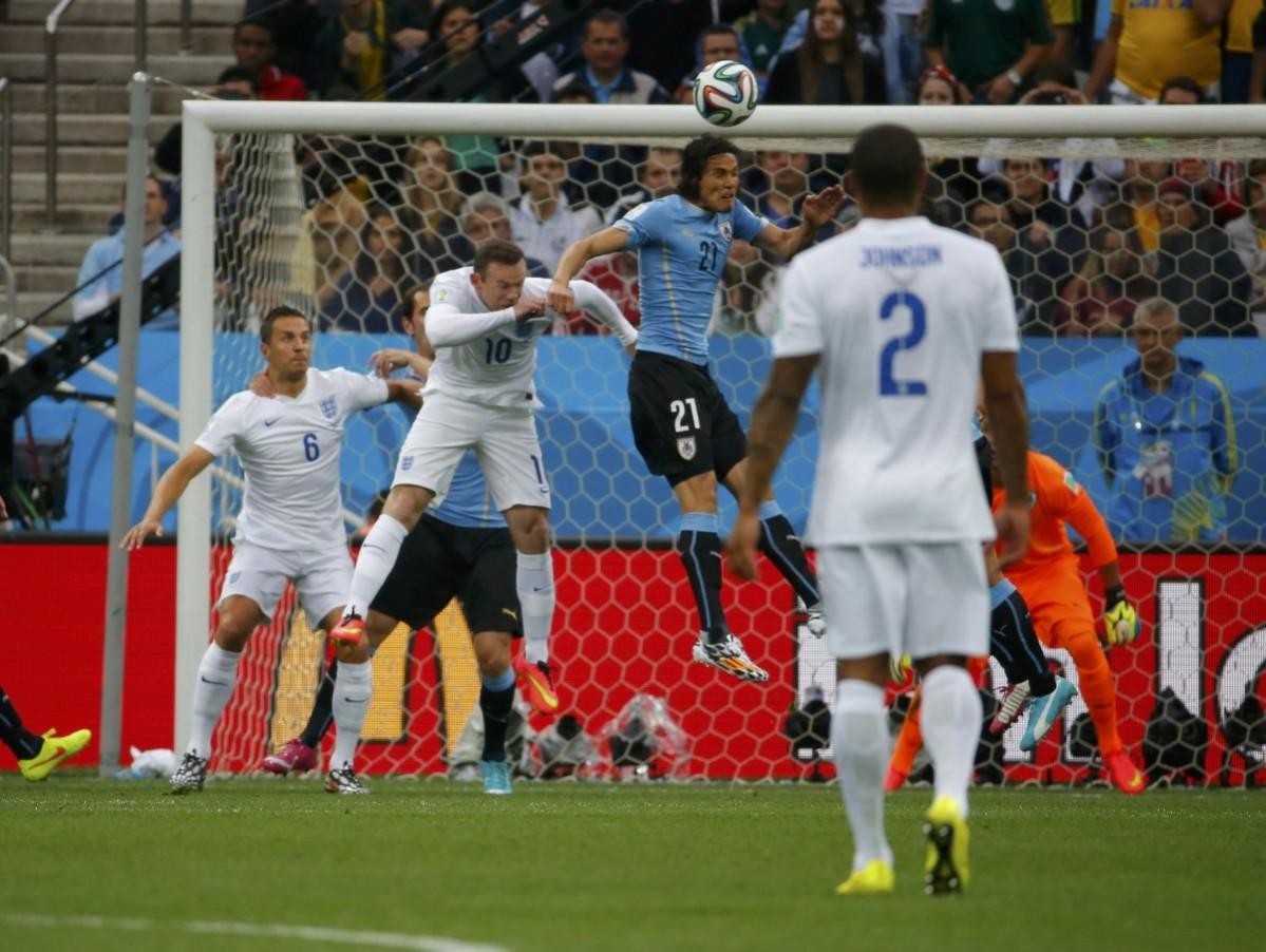 Uruguay's Cavani jumps for the ball with England's Rooney during their 2014 World Cup Group D soccer match in Sao Paulo Uruguay v England
