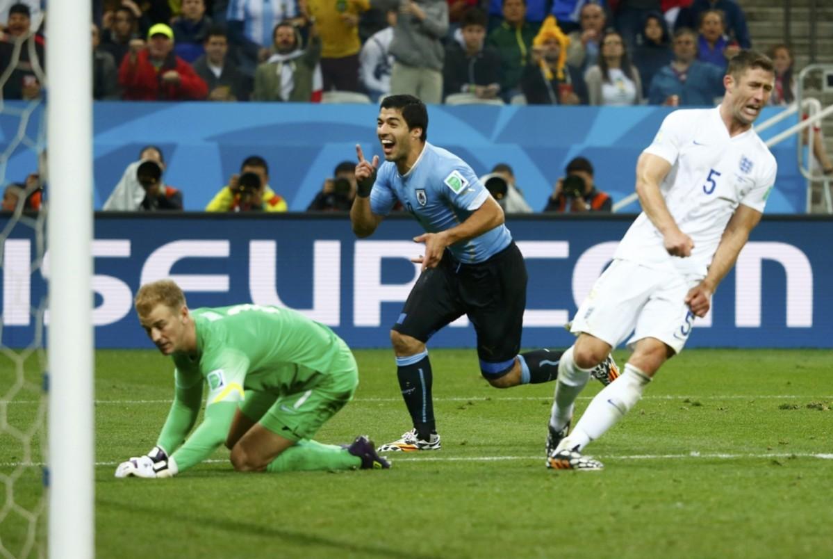 England's Cahill and Hart react as Uruguay's Suarez celebrates his goal during their 2014 World Cup Group D soccer match at the Corinthians arena in Sao Paulo Uruguay v England