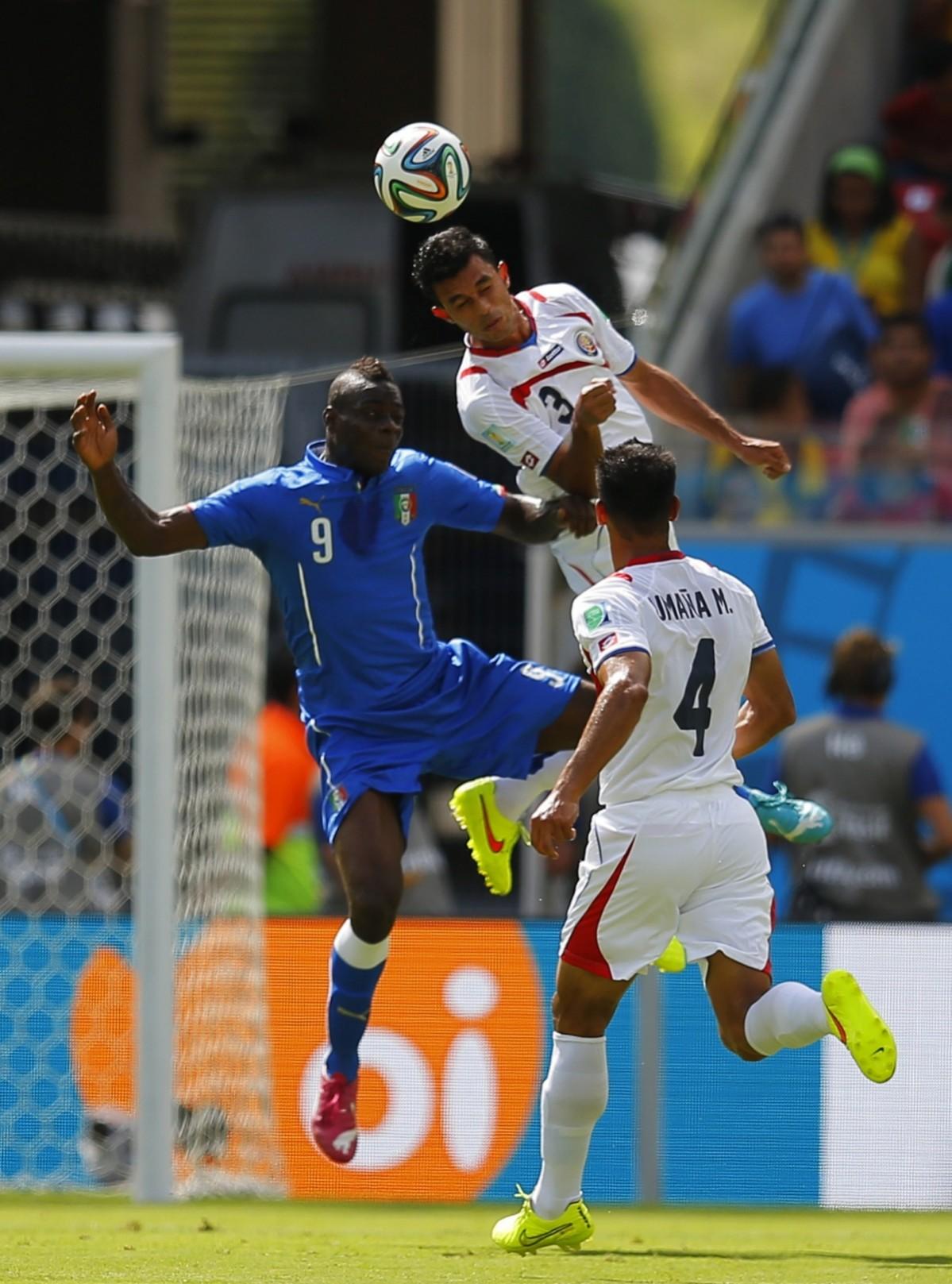 Italy's Balotelli fights for the ball with Costa Rica's Umana and Gonzalez during their 2014 World Cup Group D soccer match at the Pernambuco arena in Recife Italy vs Costa Rica