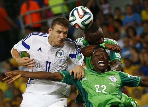 Bosnia's Edin Dzeko heads the ball next to Nigeria's Kenneth Omeruo. Edin Dzeko