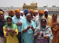 Relatives pose with the photographs of Indian workers, who have been kidnapped in Iraq, in front of the holy Sikh shrine, the Golden Temple, in Amritsar