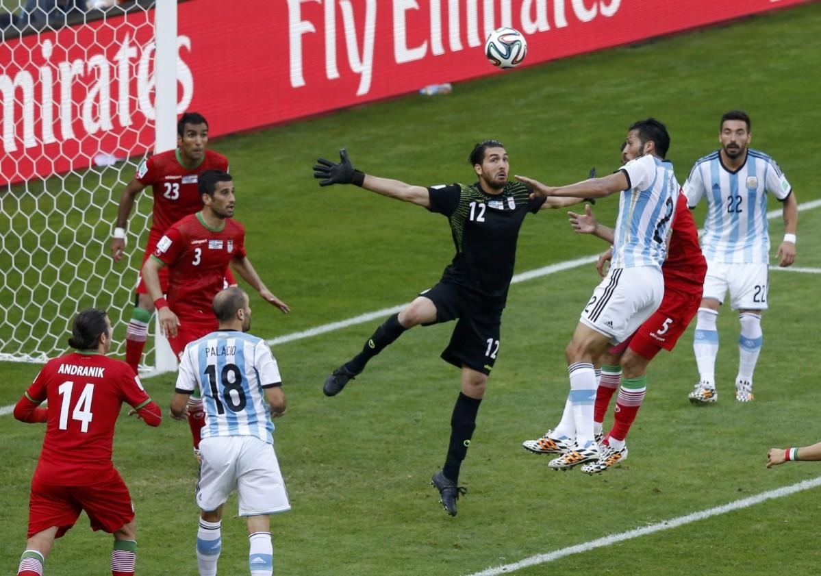Iran's Alireza Haghighi jumps for the ball against Argentina's Ezequiel Garay during their 2014 World Cup Group F match at the Mineirao stadium in Belo Horizonte Argentina vs Iran