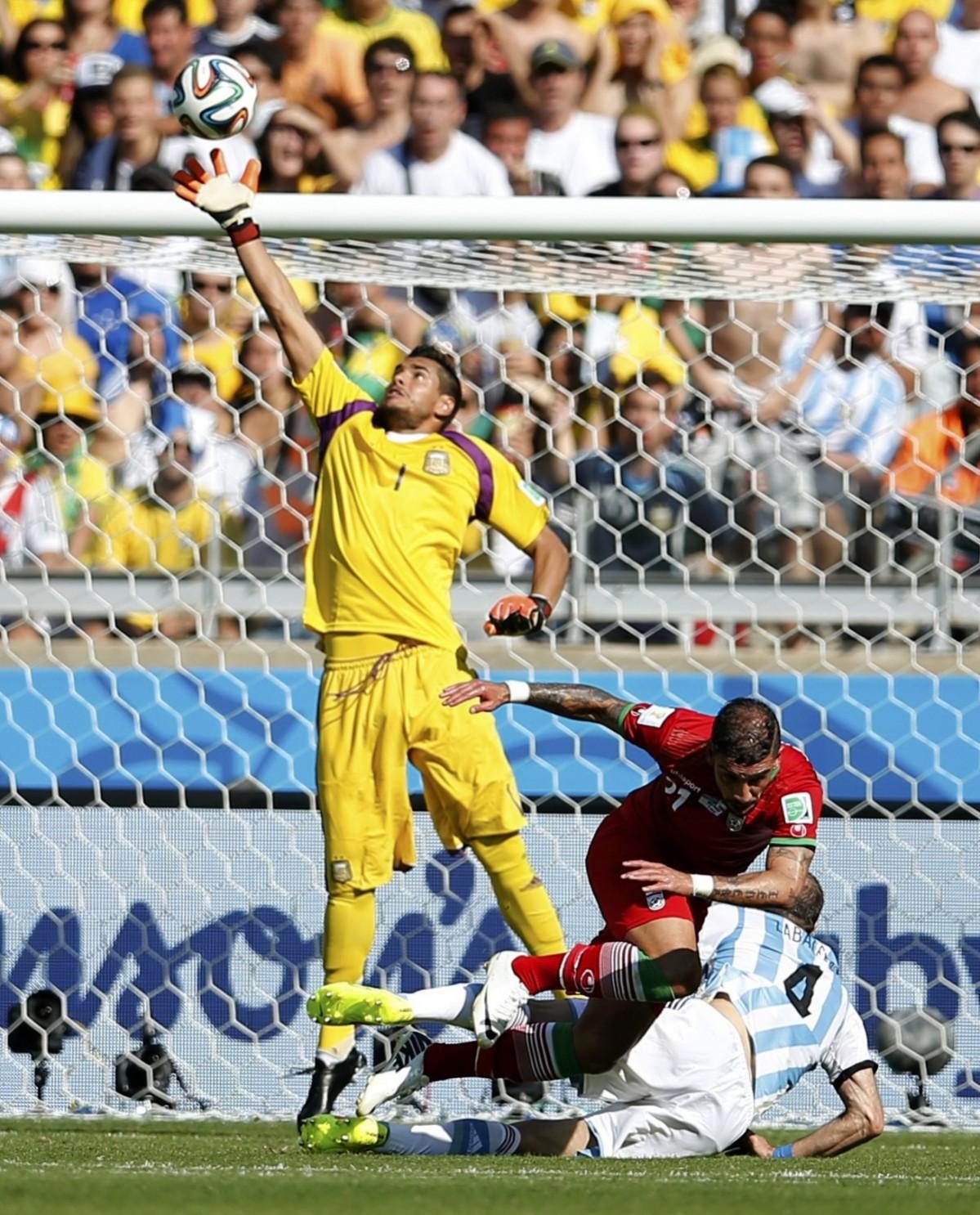 Argentina's goalkeeper Sergio Romero makes a save against a header by Iran's Ashkan Dejagah during their 2014 World Cup Group F match at the the Mineirao stadium Argentina vs Iran