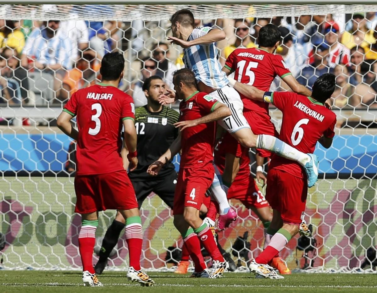 Argentina's Fernandez tries to get past a scrum of Iranian players during their 2014 World Cup Group F match at the Mineirao stadium in Belo Horizonte Argentina vs Iran