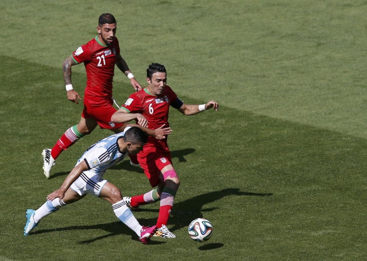 Argentina's Sergio Aguero fights for the ball against Iran's Ashkan Dejagah and Javad Nekounam during their 2014 World Cup Group F match at the Mineirao stadium in Belo Horizonte Argentina vs Iran