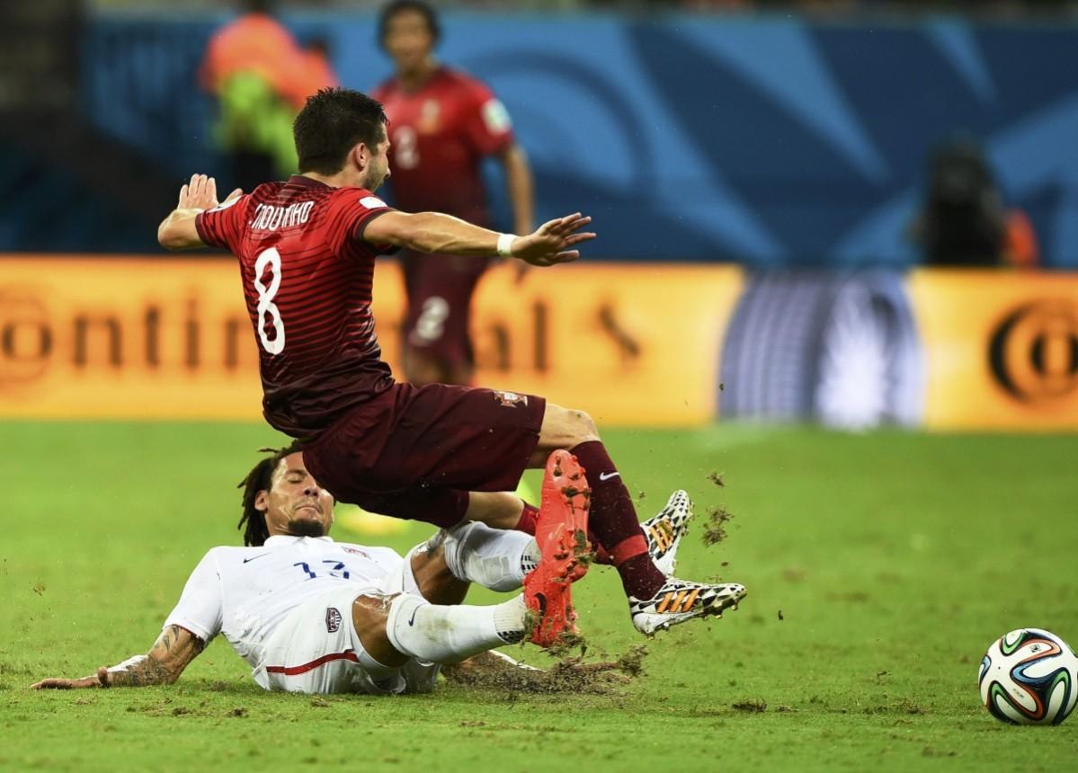 Jones of the U.S. tackles Portugal's Moutinho and receives a yellow card, during their 2014 World Cup G match at the Amazonia arena in Manaus USA vs Portugal