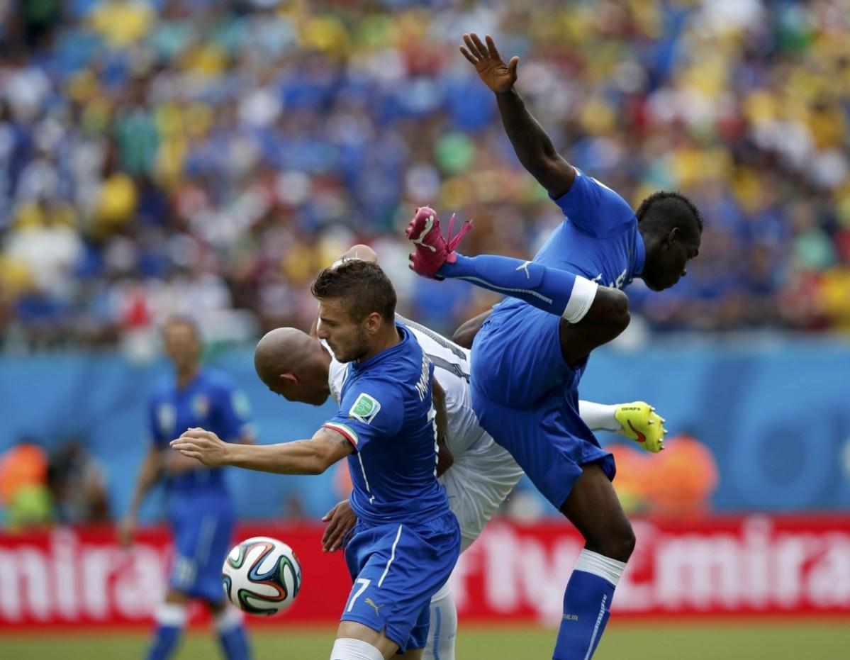 Italy's Ignazio Abate and Mario Balotelli fight for the ball against Uruguay's Egidio Arevalo Rios during their 2014 World Cup Group D match at the Dunas arena in Nata Italy vs Uruguay