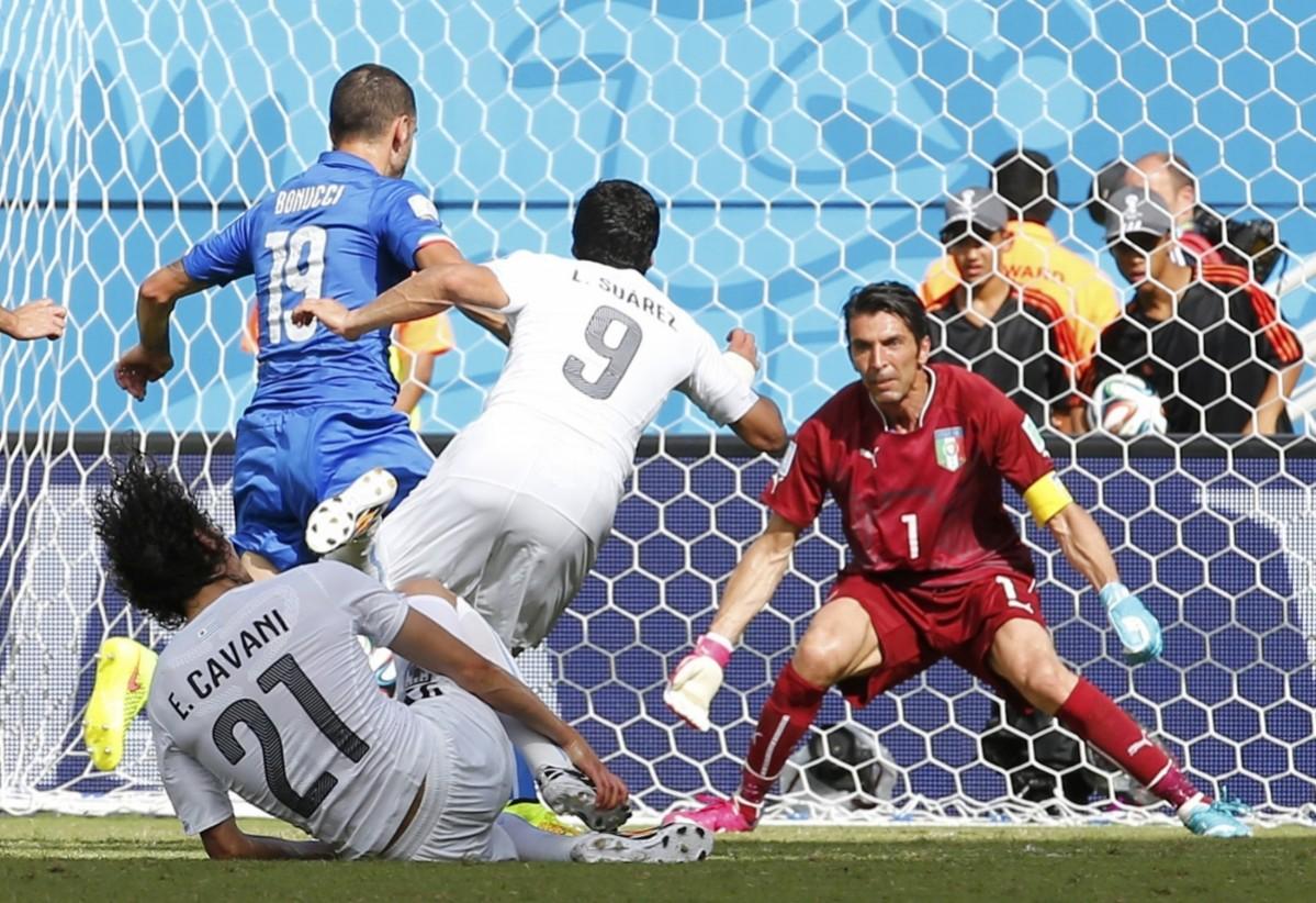 Uruguay's Luis Suarez tries to score against Italy's goalkeeper Gianluigi Buffon during their 2014 World Cup Group D match at the Dunas arena Italy vs Costa Rica
