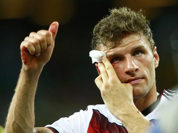 Germany's Thomas Mueller gives a thumbs up while holding his bleeding head. Thomas Mueller