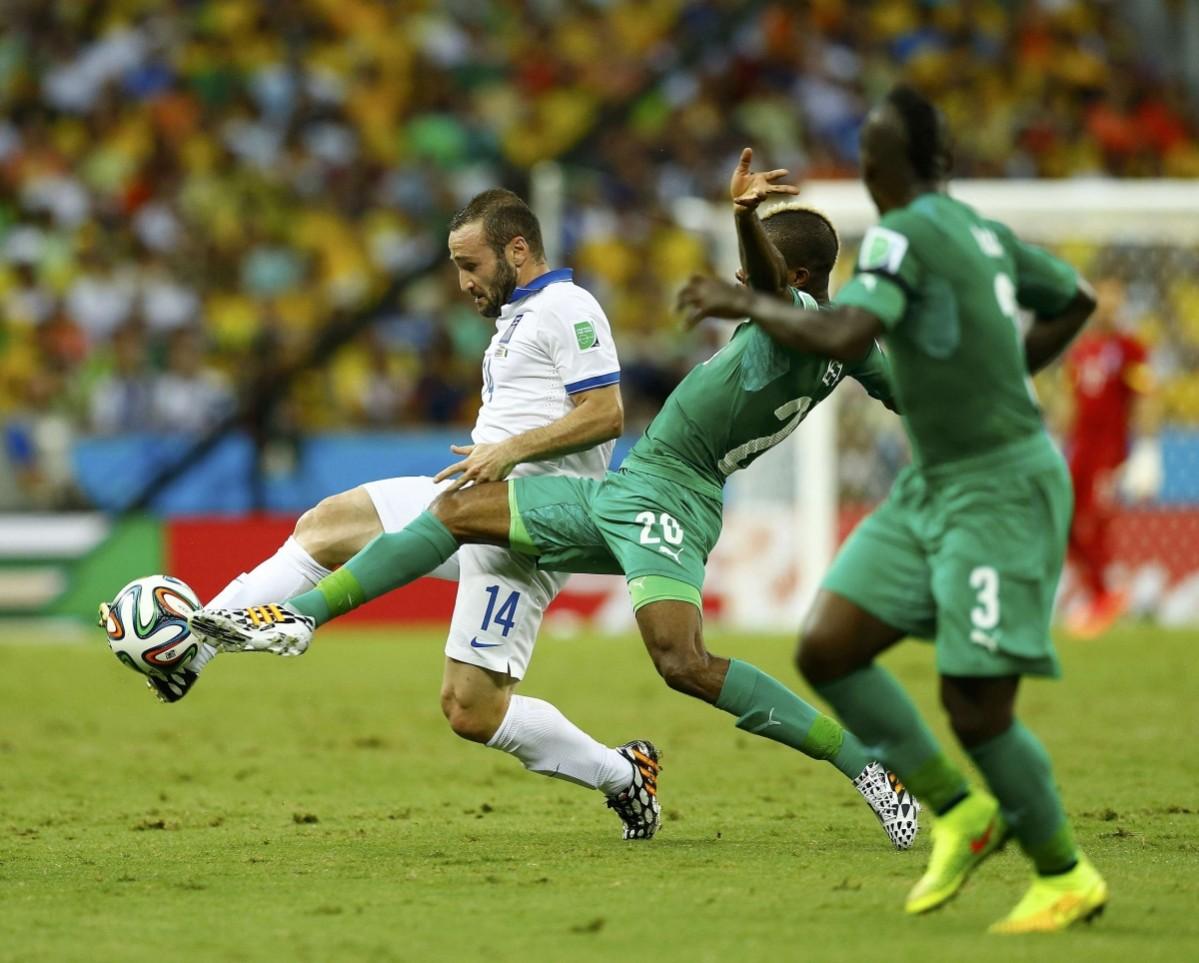 Greece's Salpingidis fights for the ball with Ivory Coast's Die and Boka during their 2014 World Cup Group C soccer match at the Castelao arena in Fortaleza Greece vs Ivory Coast