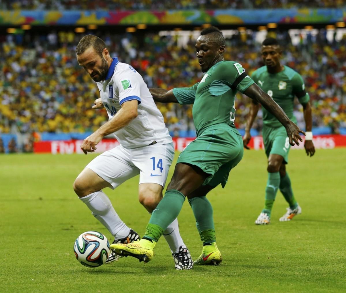 Greece's Salpingidis fights for the ball with Ivory Coast's Boka during their 2014 World Cup Group C soccer match at the Castelao arena in Fortaleza Greece vs Ivory Coast