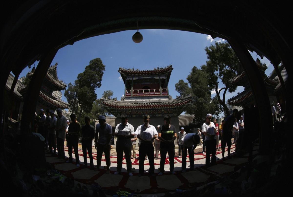 People attend a Friday prayer outside a worship hall of the Niujie Mosque in Beijing, ahead of the holy fasting month of Ramadan Ramadan 2014