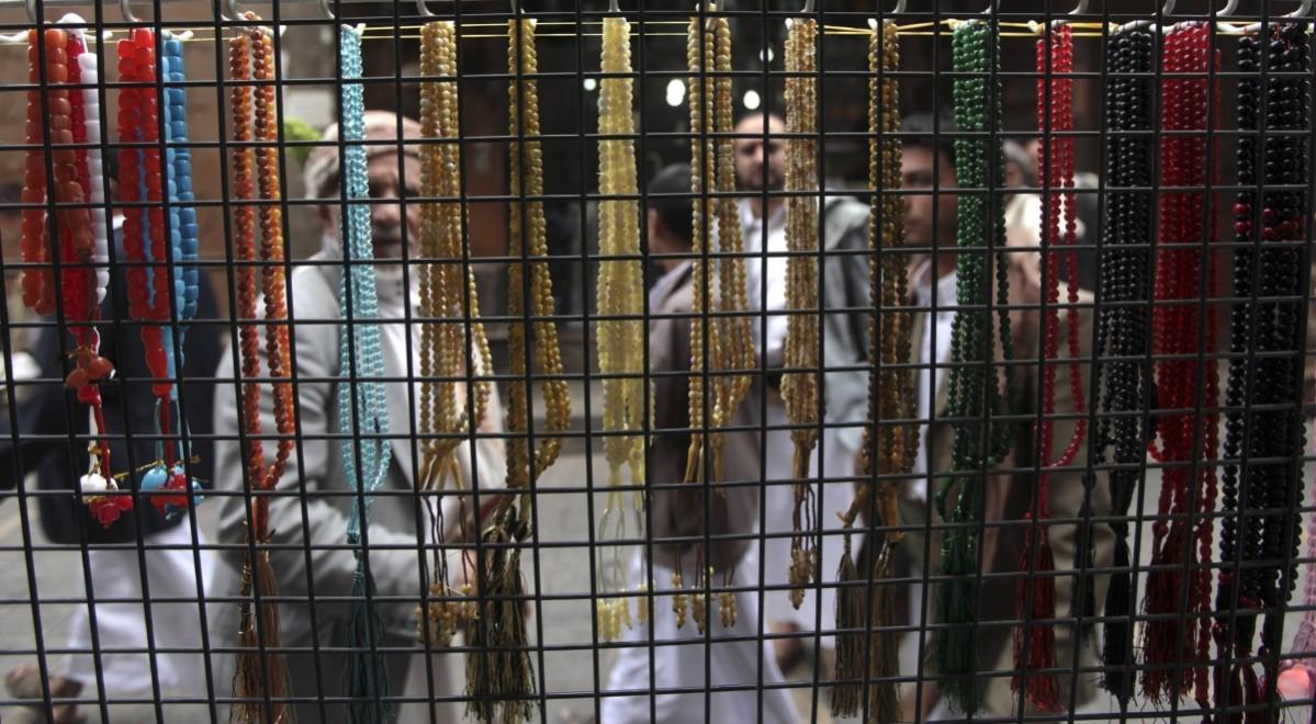 Passers-by look at prayer beads on display at a market in Sanaa ahead of Ramadan Ramadan 2014