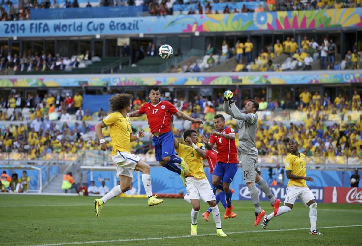 Chile's Gary Medel and Eduardo Vargas try to score past Brazil's goalkeeper Julio Cesar during their 2014 World Cup round of 16 game at the Mineirao stadium Brazil v Chile