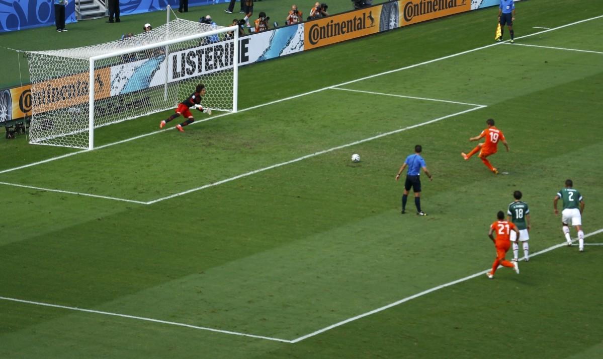 Klaas-Jan Huntelaar of the Netherlands scores past Mexico's goalkeeper Guillermo Ochoa during their 2014 World Cup round of 16 game at the Castelao arena Netherlands vs Mexico