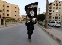 A member loyal to the ISIS waves the flag in Raqqa